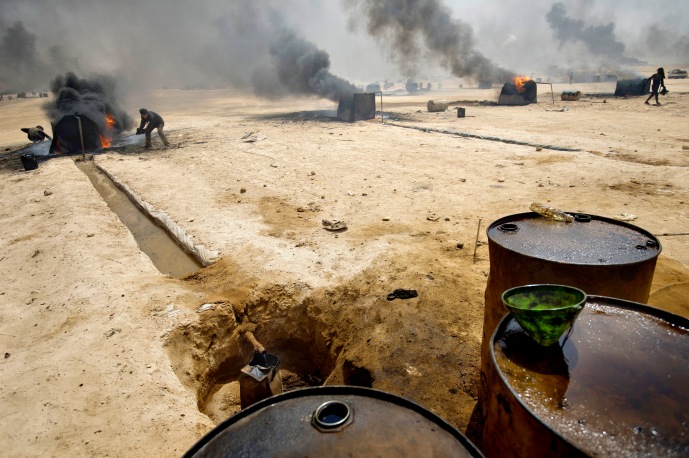 Recuperation de petrole a la raffinerie d'Al Mansoura, controlee par les djihadistes de l'Etat Islamique